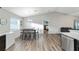 Sunlit dining area with wood-look floors adjacent to the open kitchen and living spaces at 4955 Se 89Th Place Rd, Ocala, FL 34480