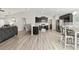 Open-concept kitchen and dining area featuring stainless steel appliances, dark cabinetry and bar seating at 4955 Se 89Th Place Rd, Ocala, FL 34480