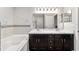 Well-lit main bathroom with double sink vanity, modern fixtures and relaxing soaking tub at 4955 Se 89Th Place Rd, Ocala, FL 34480