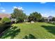 Well-maintained backyard with a brick firepit, vibrant green lawn, and a secure black metal fence for added privacy at 4970 Nw 35Th Lane Rd, Ocala, FL 34482