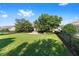 Spacious backyard with lush green grass, a brick firepit area, and black metal fencing for a private outdoor space at 4970 Nw 35Th Lane Rd, Ocala, FL 34482