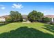 Large backyard featuring a brick firepit area, manicured lawn, and secure black metal fencing around the property at 4970 Nw 35Th Lane Rd, Ocala, FL 34482