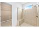 Bathroom features a glass shower with bench and tile surround, and a view into the walk-in closet at 4970 Nw 35Th Lane Rd, Ocala, FL 34482