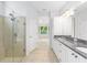 Bathroom with granite counters, double sink, glass shower and tile surround at 4970 Nw 35Th Lane Rd, Ocala, FL 34482