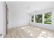 This bright bedroom features a view of nature out the windows, light walls and wood-look floors at 4970 Nw 35Th Lane Rd, Ocala, FL 34482
