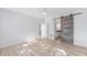 This bright bedroom features a sliding barn door, light walls and wood-look floors at 4970 Nw 35Th Lane Rd, Ocala, FL 34482
