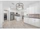 Bright kitchen features stainless appliances, white cabinets, granite counters, an island, and tile backsplash at 4970 Nw 35Th Lane Rd, Ocala, FL 34482