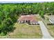 A stunning aerial view of the property showcasing its well-manicured lawn, mature trees, and convenient driveway at 4973 Sw 107Th Loop, Ocala, FL 34476