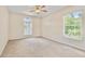 Bright bedroom with a ceiling fan, two windows and ample natural light overlooking surrounding greenery at 4973 Sw 107Th Loop, Ocala, FL 34476