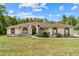 Charming single-story home featuring arched windows and a meticulously landscaped front yard at 4973 Sw 107Th Loop, Ocala, FL 34476