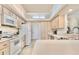 Functional kitchen featuring white appliances, ample cabinet space, and a well-lit skylight at 4973 Sw 107Th Loop, Ocala, FL 34476