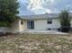 Backyard with a patio and sliding glass door leading into the house, small window on the back of the house at 499 Water Rd, Ocala, FL 34472