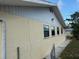 Exterior view featuring stucco siding with multiple windows and a paved walkway around the house at 499 Water Rd, Ocala, FL 34472