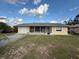 Well-kept home with a spacious front yard, featuring a screened-in porch and attached garage at 499 Water Rd, Ocala, FL 34472