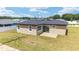 Back exterior view of a house, featuring a sliding glass door and concrete patio overlooking the yard at 5 Dogwood Loop Ave, Ocala, FL 34472