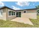 A view of the exterior backyard with a small patio and green grass at 5 Dogwood Loop Ave, Ocala, FL 34472