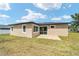 A view of the exterior backyard with a small patio and green grass at 5 Dogwood Loop Ave, Ocala, FL 34472
