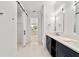 Bright bathroom featuring double vanity with modern lighting and sliding barn door at 5 Dogwood Loop Ave, Ocala, FL 34472