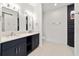 Bathroom features dual sinks, modern lighting, and walk-in shower with dark tile at 5 Dogwood Loop Ave, Ocala, FL 34472
