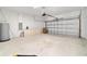 Spacious garage with a clean concrete floor and a functional roll-up door at 5 Dogwood Loop Ave, Ocala, FL 34472