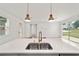 Close-up on kitchen island with stainless steel sink, and views to windows, doors, and more living space at 5 Dogwood Loop Ave, Ocala, FL 34472