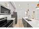 Modern kitchen featuring gray cabinets, quartz countertops, and stainless steel appliances at 5 Dogwood Loop Ave, Ocala, FL 34472