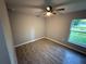 This bedroom has wood-look tile floors, a ceiling fan, and a window providing natural light at 5 Laurel Pass Ln, Ocala, FL 34472
