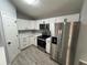 Well-lit kitchen with white cabinets, stainless steel appliances, and tile flooring at 5 Laurel Pass Ln, Ocala, FL 34472