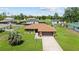 Aerial view of stone house exterior, well-manicured lawn, and driveway with palm tree at 501 Marion Oaks Dr, Ocala, FL 34473