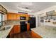 Functional kitchen featuring wood cabinets, black appliances, and granite countertops at 501 Marion Oaks Dr, Ocala, FL 34473