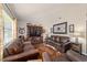 Relaxing living room with three leather couches, decorative wooden shelving, and hardwood floors at 501 Marion Oaks Dr, Ocala, FL 34473