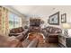 Cozy living room with leather seating, wooden accents, and natural light from the window at 501 Marion Oaks Dr, Ocala, FL 34473