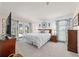 Spacious main bedroom featuring white bedding, accent wall and a sliding glass door at 501 Marion Oaks Dr, Ocala, FL 34473