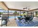 Inviting screened patio with a dining set, grill, ceiling fans, overlooking the pool at 501 Marion Oaks Dr, Ocala, FL 34473