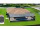 Aerial view of an enclosed pool with an immaculate green lawn and a brown roof at 501 Marion Oaks Dr, Ocala, FL 34473