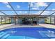 A full view of the pool, covered patio, and the home's exterior within the screened-in lanai at 501 Marion Oaks Dr, Ocala, FL 34473