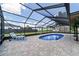 A chaise lounge is positioned beside the pool in the screened-in lanai at 501 Marion Oaks Dr, Ocala, FL 34473