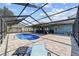 Screened-in pool area has an in-ground pool, lounge chairs, and a covered patio with a grill at 501 Marion Oaks Dr, Ocala, FL 34473