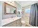 Neutral bathroom featuring a modern vanity with framed mirror, toilet, and shower with a blue curtain at 5459 Sw 86Th St, Ocala, FL 34476