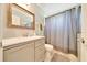 Neutral bathroom featuring a modern vanity with framed mirror, toilet, and shower with a gray curtain at 5459 Sw 86Th St, Ocala, FL 34476