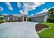 Charming home featuring a well-manicured lawn, mature plantings, long driveway, and a welcoming red front door at 5459 Sw 86Th St, Ocala, FL 34476