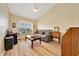 Bright living room with vaulted ceilings, a ceiling fan, a large window, and wood-look laminate floors at 5459 Sw 86Th St, Ocala, FL 34476