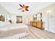 Bright main bedroom with wood floors, dresser, and vanity with mirrors at 5459 Sw 86Th St, Ocala, FL 34476