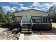 Home featuring a back entry with wooden deck and steps at 5862 Sw 160Th Ct, Ocala, FL 34481
