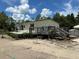 Home featuring a wooden deck and stairs, open carport and gravel area at 5862 Sw 160Th Ct, Ocala, FL 34481