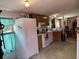 Traditional kitchen with wooden cabinets, white appliances and light green flooring at 5862 Sw 160Th Ct, Ocala, FL 34481