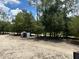 The rear of the property has a utilitarian shed, bordered by many trees on a bright day at 5862 Sw 160Th Ct, Ocala, FL 34481