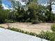 View of the yard from the deck, showing sand and surrounding trees at 5862 Sw 160Th Ct, Ocala, FL 34481