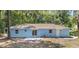 Back exterior features a freshly painted light blue home with a sliding glass door and concrete patio at 6475 Nw 61St Ave, Ocala, FL 34482