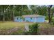 Exterior shot of light blue home featuring back yard and patio at 6475 Nw 61St Ave, Ocala, FL 34482